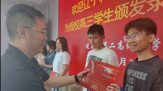 图为 澳门银银河7163党委副书记宋明凯为凌源第二高级中学学生颁发录取通知书